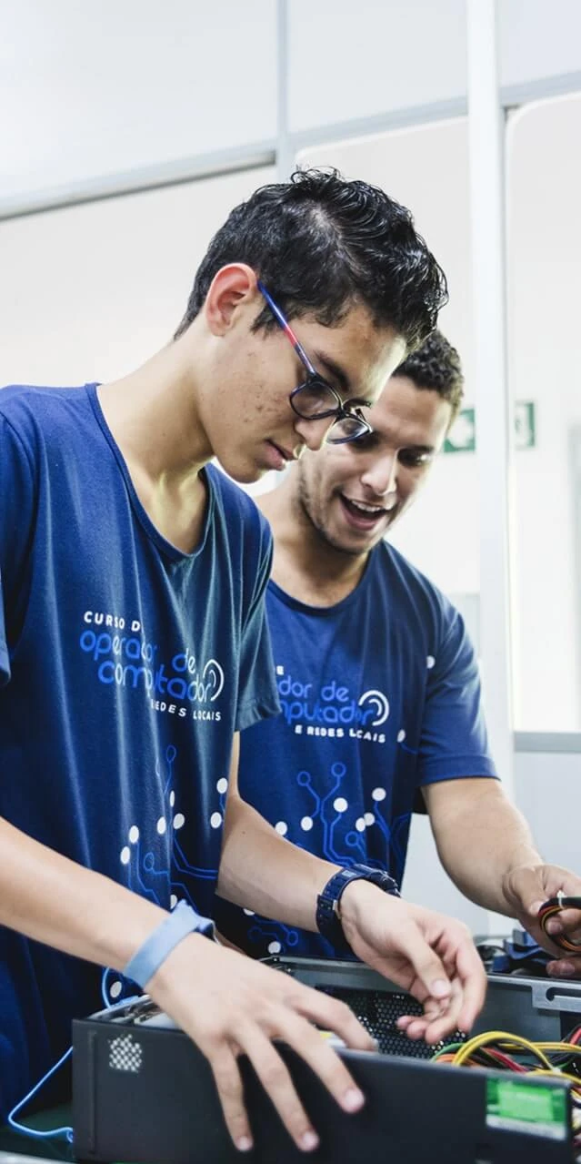 Rapaz de óculos e colega moreno sem óculos sorrindo em curso do Instituto Ramacrisna